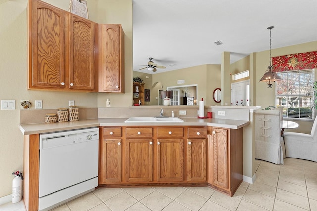 kitchen with white dishwasher, sink, decorative light fixtures, and light tile patterned flooring