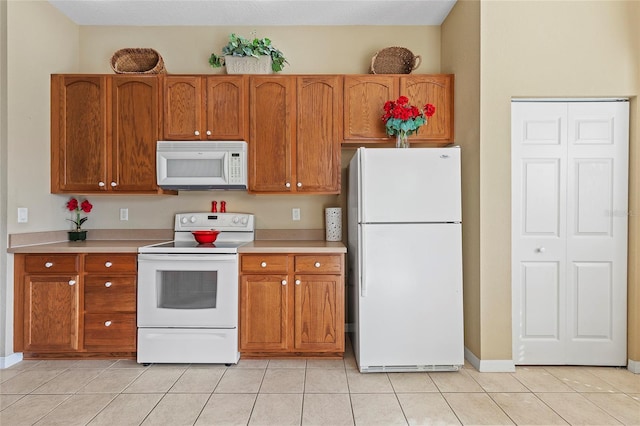 kitchen with light tile patterned flooring and white appliances