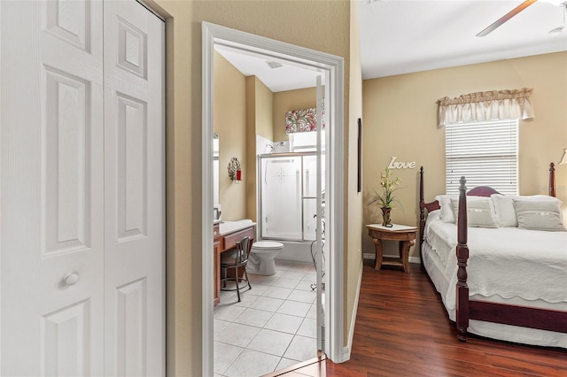 bedroom with hardwood / wood-style floors and connected bathroom