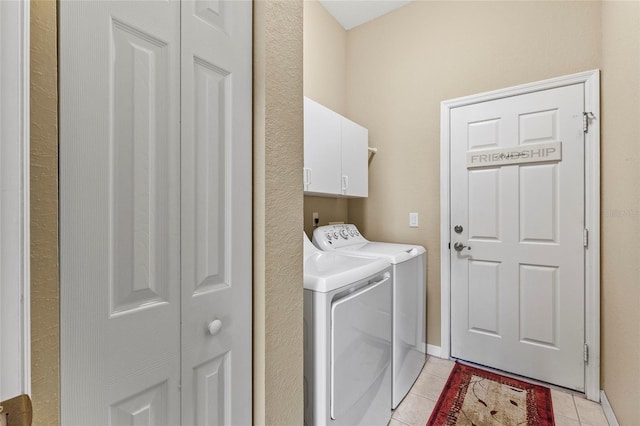 laundry area featuring independent washer and dryer, cabinets, and light tile patterned floors