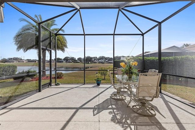 sunroom featuring a water view