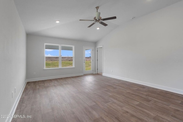 spare room with wood finished floors, ceiling fan, baseboards, and lofted ceiling