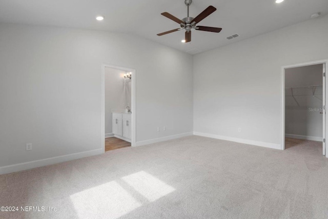 unfurnished bedroom with a spacious closet, recessed lighting, visible vents, and light carpet