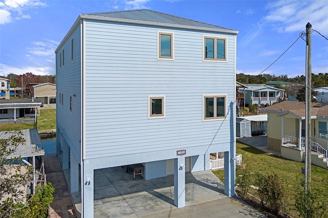 exterior space featuring driveway, a residential view, and metal roof