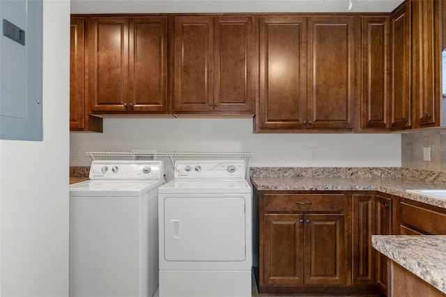 washroom with washing machine and dryer, electric panel, and cabinet space