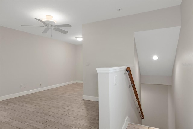 unfurnished room with ceiling fan, light wood-type flooring, and baseboards