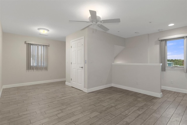 unfurnished room with light wood-style flooring, baseboards, and a ceiling fan