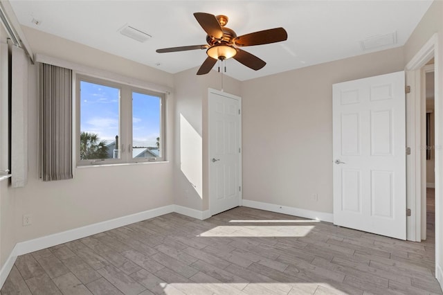 unfurnished bedroom with visible vents, a ceiling fan, light wood-style flooring, and baseboards