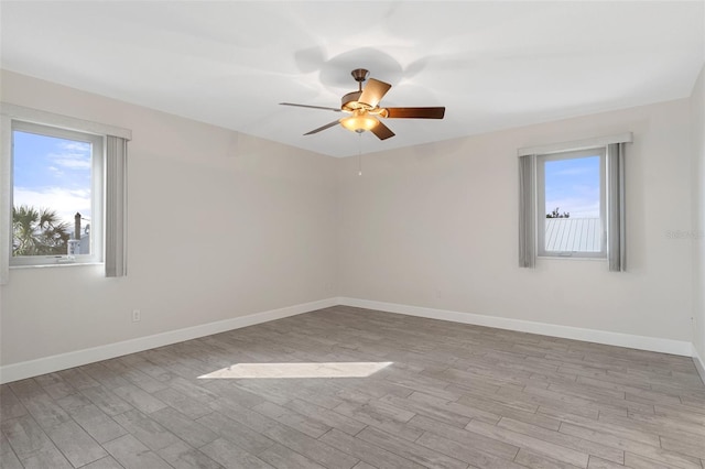 unfurnished room with light wood finished floors, baseboards, and a ceiling fan