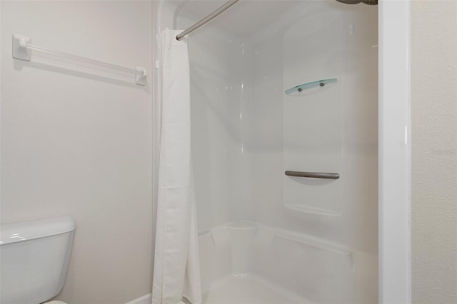 full bathroom with toilet and a shower with curtain