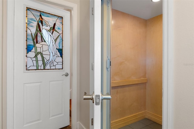 doorway to outside with baseboards and tile patterned floors