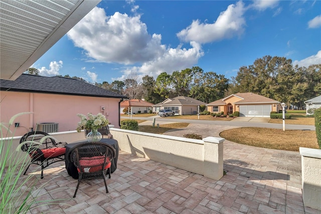 view of patio with central AC unit and a garage