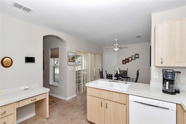 kitchen with dishwasher, sink, a textured ceiling, and light brown cabinetry