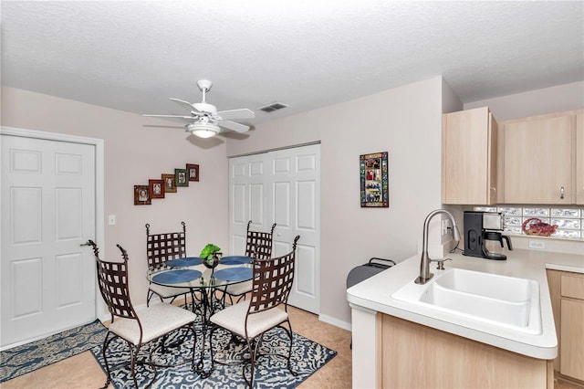 dining room with sink, a textured ceiling, and ceiling fan