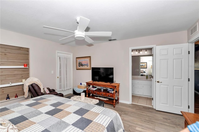 bedroom with connected bathroom, ceiling fan, and light hardwood / wood-style flooring