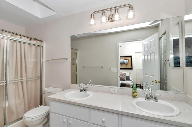 bathroom featuring vanity, toilet, a skylight, and a shower with shower curtain