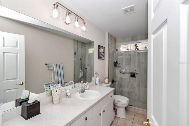 bathroom featuring vanity, tile patterned flooring, toilet, and walk in shower