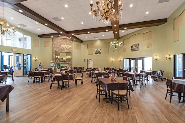 dining room with beamed ceiling, light hardwood / wood-style floors, french doors, and a chandelier