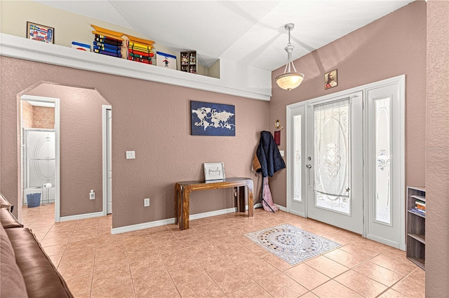 tiled foyer entrance featuring vaulted ceiling
