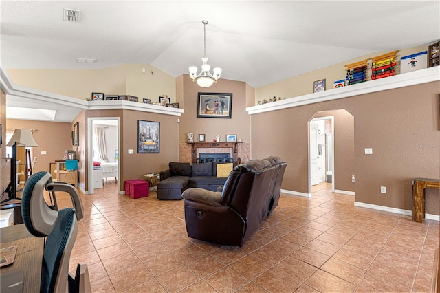 living room with a tiled fireplace, a notable chandelier, vaulted ceiling, and tile patterned floors