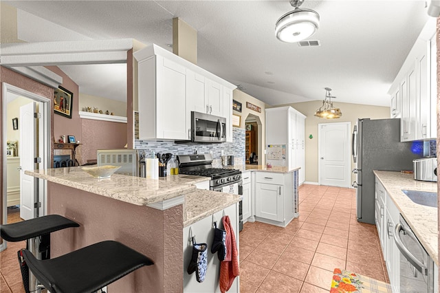 kitchen featuring white cabinetry, a breakfast bar, appliances with stainless steel finishes, and kitchen peninsula