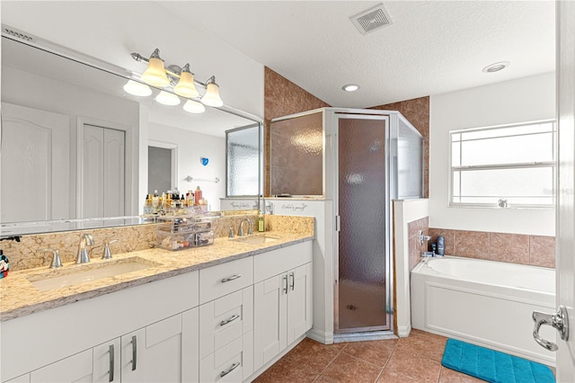 bathroom featuring vanity, independent shower and bath, tile patterned flooring, and a textured ceiling