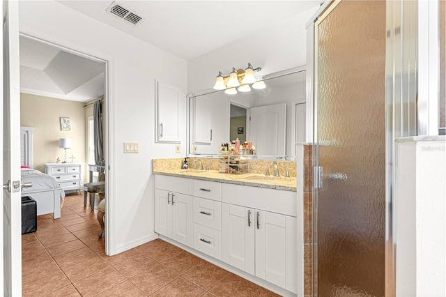 bathroom featuring tile patterned flooring, an enclosed shower, and vanity
