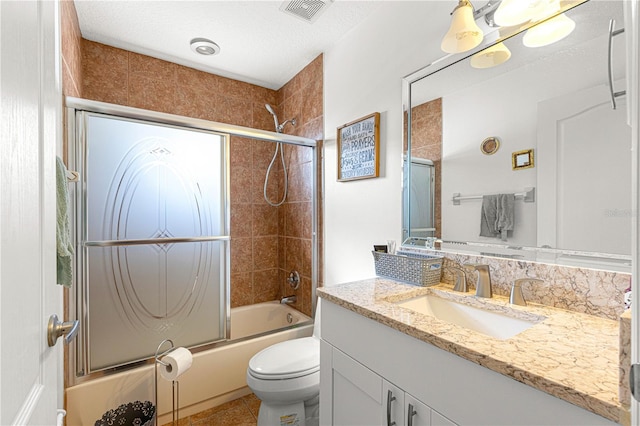 full bathroom featuring tile patterned flooring, enclosed tub / shower combo, vanity, toilet, and a textured ceiling