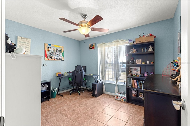 tiled office space with a textured ceiling and ceiling fan