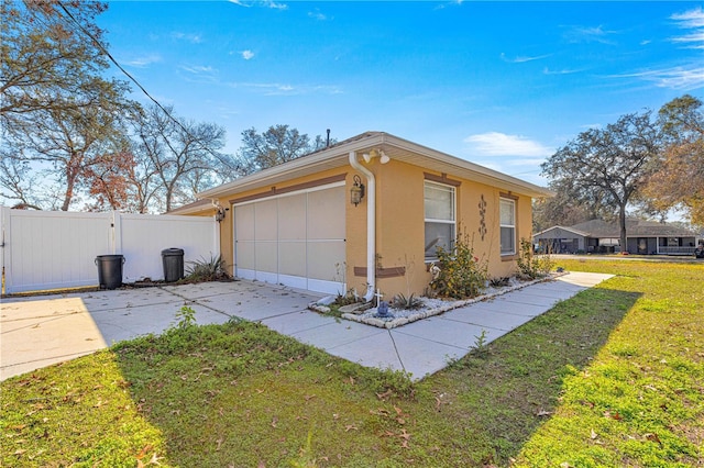 view of side of home featuring a garage and a lawn