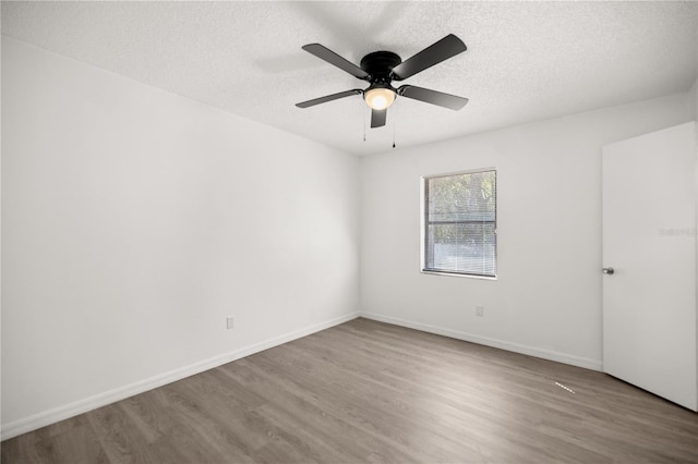 spare room featuring ceiling fan, hardwood / wood-style floors, and a textured ceiling