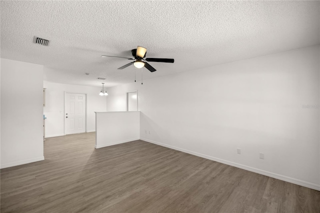 empty room with dark wood-type flooring, ceiling fan, and a textured ceiling