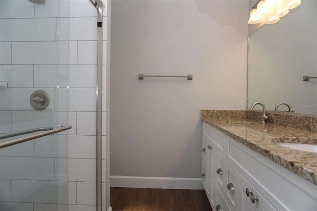 bathroom featuring an enclosed shower, vanity, and wood-type flooring