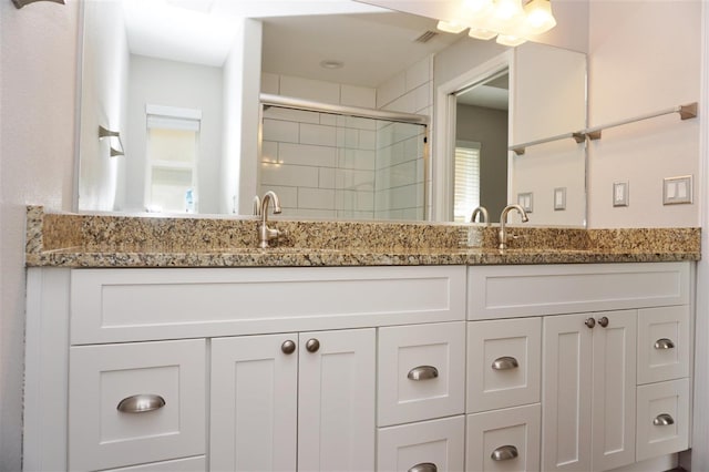 bathroom featuring vanity and a shower with shower door