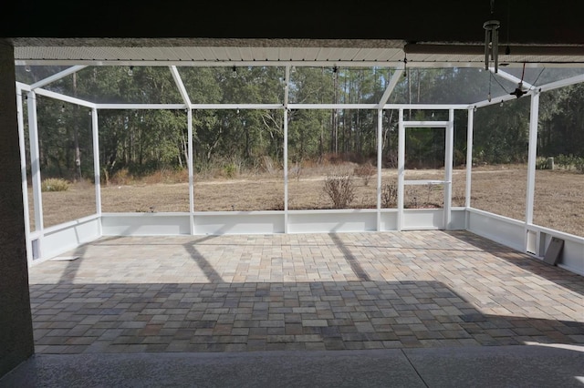 view of patio featuring glass enclosure