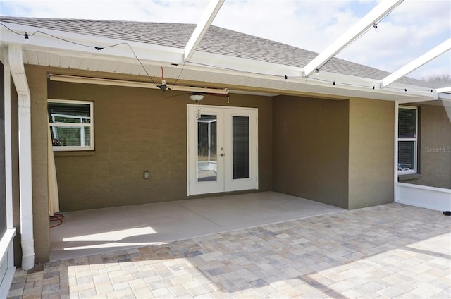 view of patio featuring ceiling fan and glass enclosure