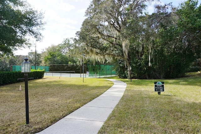 surrounding community featuring a yard and tennis court