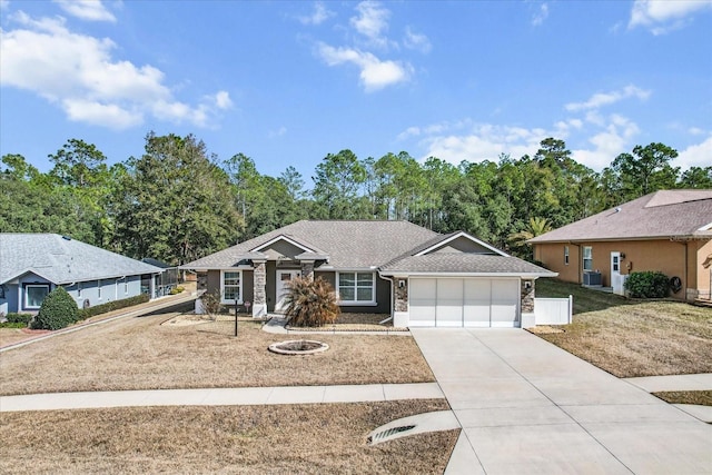 ranch-style home featuring cooling unit, a garage, and a front yard