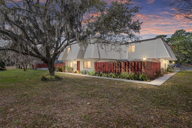 property exterior at dusk with a lawn