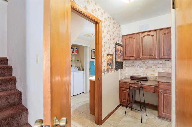 kitchen featuring light tile patterned floors, backsplash, and independent washer and dryer