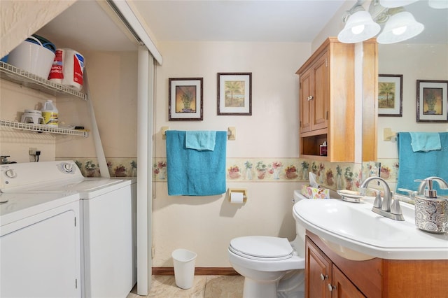 bathroom featuring washing machine and dryer, vanity, and toilet