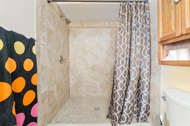 bathroom with toilet and tiled shower