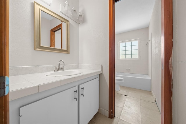 full bathroom featuring vanity, tiled shower / bath, tile patterned flooring, and toilet