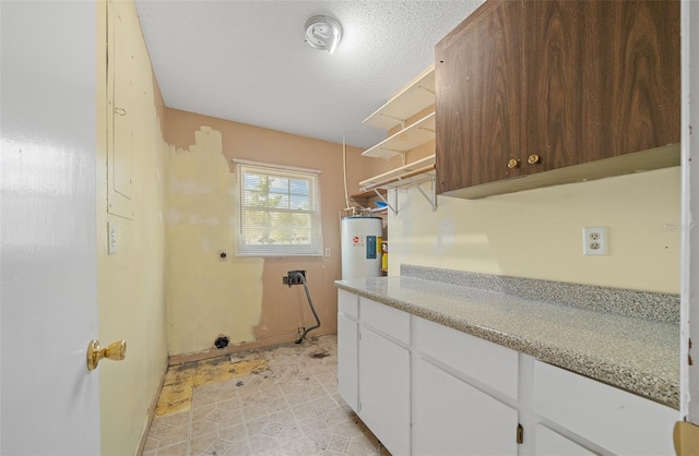 washroom featuring water heater and a textured ceiling