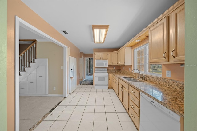 kitchen featuring light brown cabinetry, sink, light tile patterned floors, light stone countertops, and white appliances