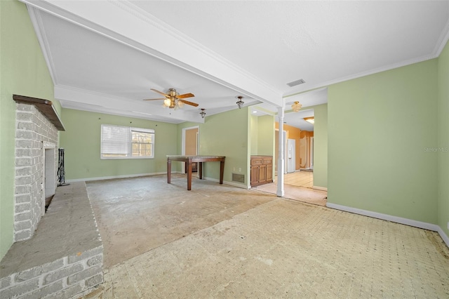 unfurnished living room featuring crown molding, ceiling fan, beam ceiling, and a brick fireplace