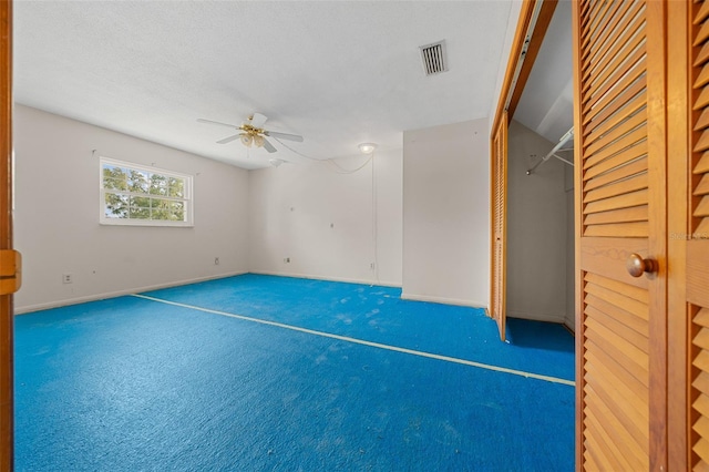 unfurnished room featuring ceiling fan, carpet, and a textured ceiling