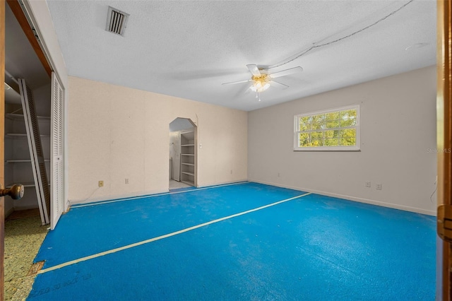 interior space with ceiling fan and a textured ceiling