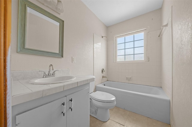 full bathroom featuring tiled shower / bath, vanity, toilet, and tile patterned flooring