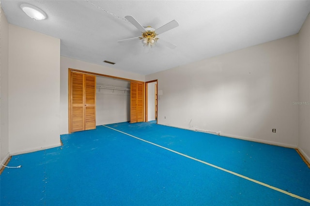 unfurnished bedroom with ceiling fan and a closet